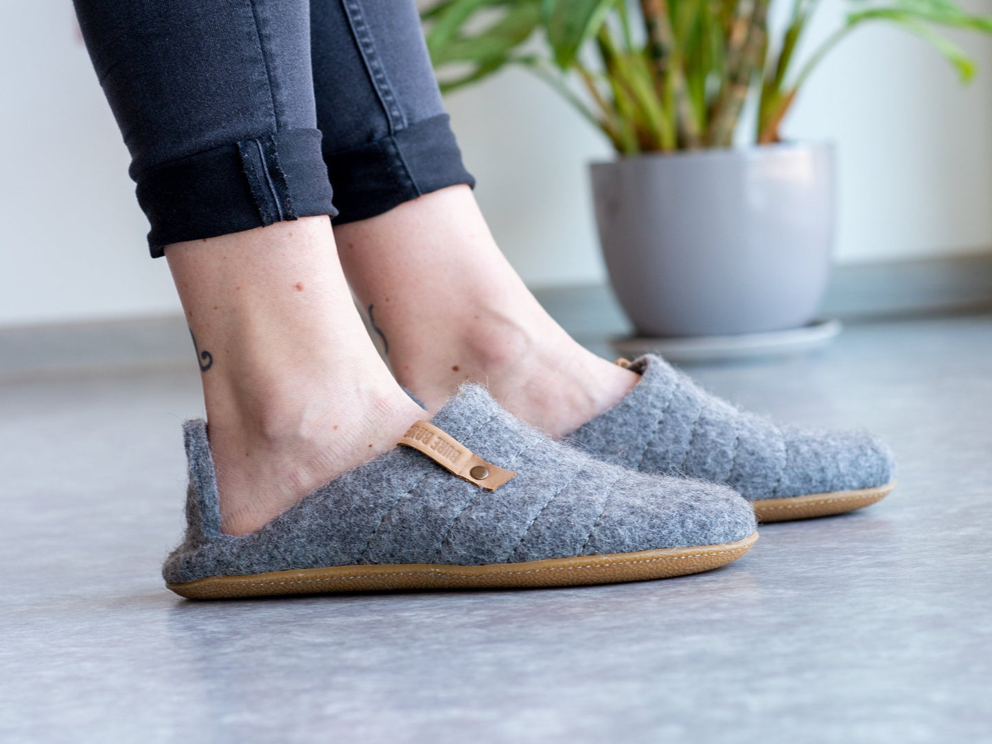 Natural gray collapsible back woolen slippers on woman's feet