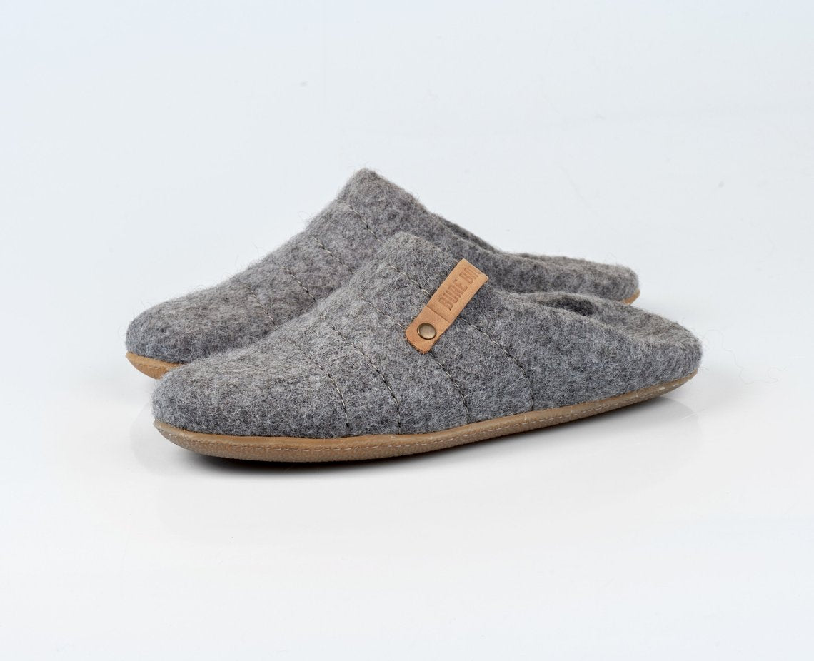 Collapsible back felted wool slippers for men with their backs folded.